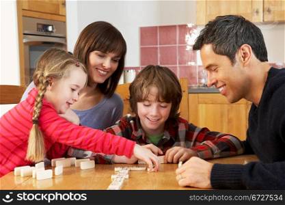 Family Playing Dominoes In Kitchen