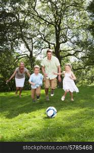 Family Playing Football In Garden