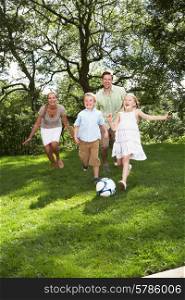 Family Playing Football In Garden
