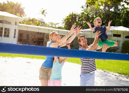 Family Playing Game Of Volleyball In Garden