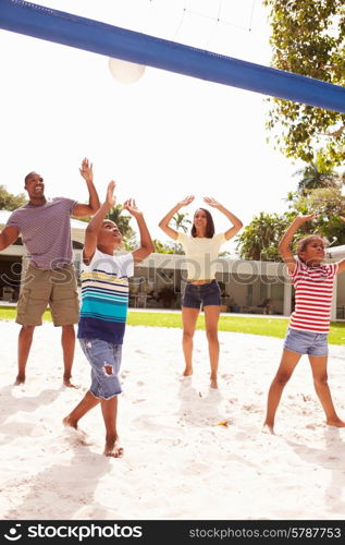 Family Playing Game Of Volleyball In Garden