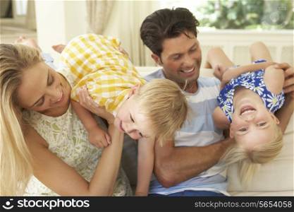Family Playing On Sofa At Home
