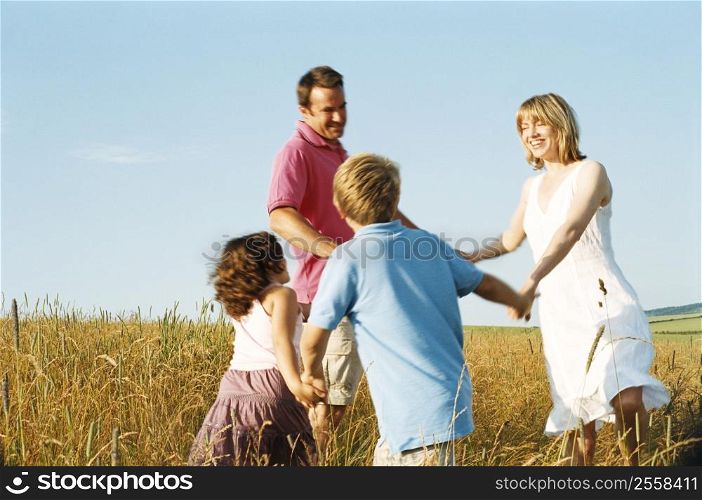 Family playing outdoors smiling