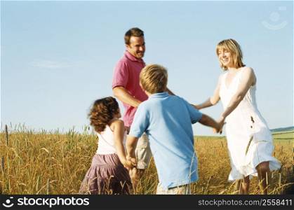 Family playing outdoors smiling
