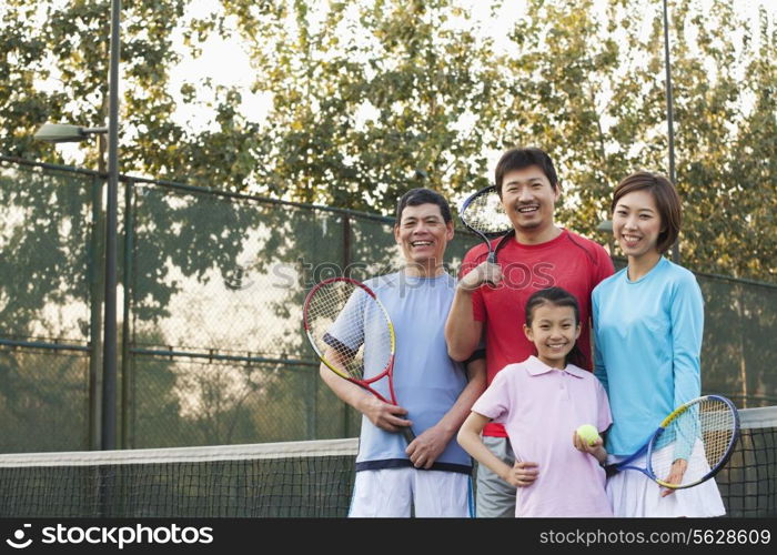 Family playing tennis, portrait