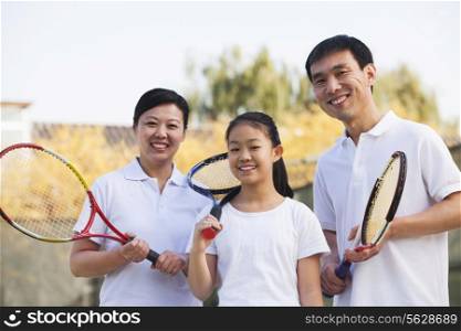 Family playing tennis, portrait