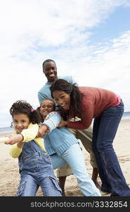 Family playing tug of war on beach