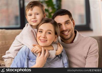 family, portrait and people concept - happy little son with mother and father at home. happy family portrait at home