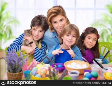  Family portrait in Easter time, creative mother with three cute adorable child coloring eggs, making vibrant colorful traditional food
