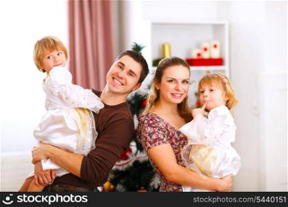 Family portrait of mother father and twins daughter near Christmas tree&#xA;