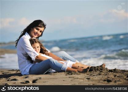 family portrait of young beautiful mom and daughter on beach