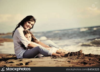 family portrait of young beautiful mom and daughter on beach