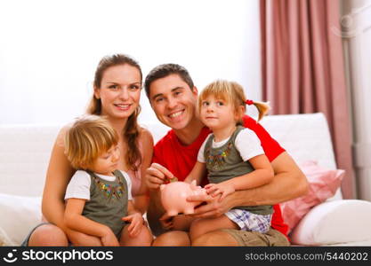 Family portrait where father putting coin to piggy bank &#xA;