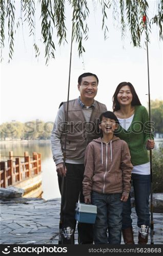 Family portrait with fishing gear at a lake