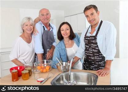 Family preparing fruit jam in home kitchen