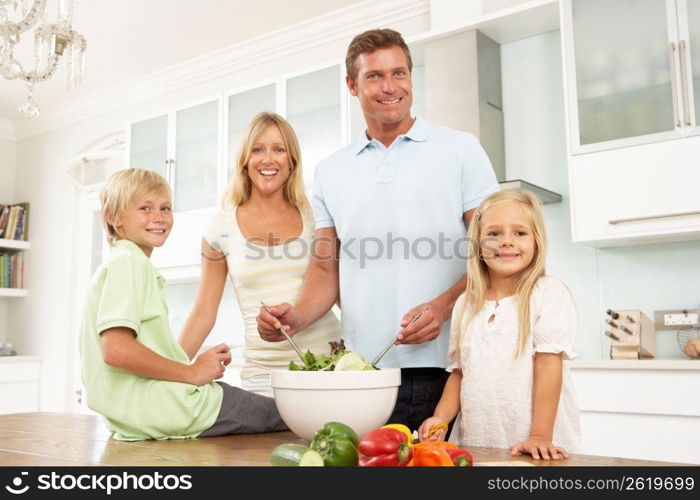 Family Preparing Salad In Modern Kitchen