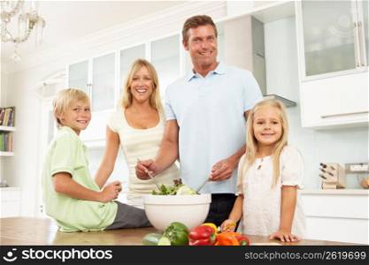 Family Preparing Salad In Modern Kitchen