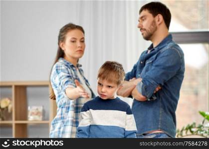 family, problem and people concept - unhappy sad little boy over arguing mother and father over home background. unhappy little boy over arguing parents at home