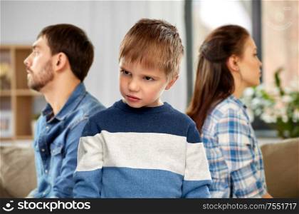family problem and social issue concept - sad little boy with unhappy parents at home. sad little boy with unhappy parents at home