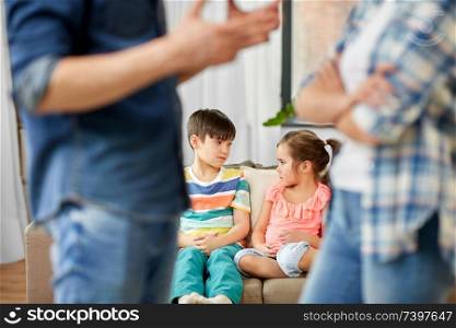 family problem, conflict and people concept - sad children watching their parents quarreling at home. children watching their parents quarreling at home