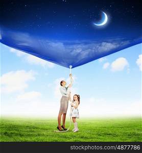 Family pulling banner. Image of young happy family pulling banner with night illustration