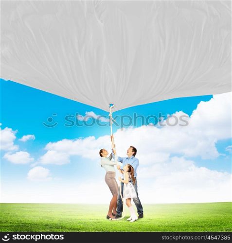 Family pulling banner. Image of young happy family pulling blank banner