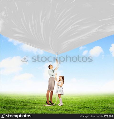 Family pulling banner. Image of young happy family pulling blank banner