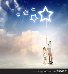 Family pulling rope with a star symbol. Image of young happy family pulling rope with a star symbol