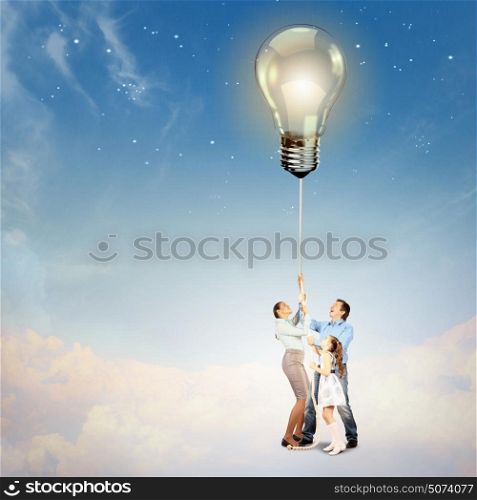 Family pulling rope with an electric bulb. Image of young happy family pulling rope with an electric bulb. Idea concept