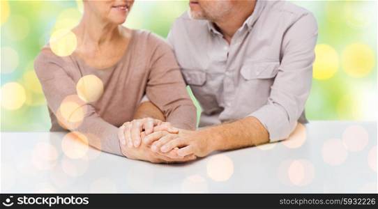 family, relations, age and people concept - close up of happy senior couple holding hands over lights background
