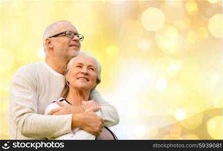 family, relations, age and people concept - happy senior couple over holiday lights background