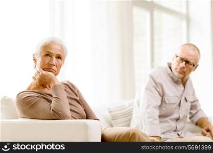 family, relations, age and people concept - senior couple sitting on sofa at home