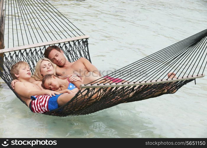 Family Relaxing In Beach Hammock