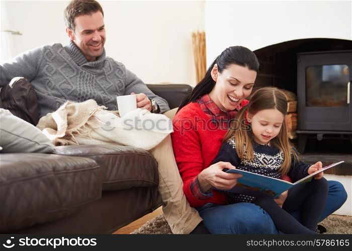 Family Relaxing Indoors And Reading Book