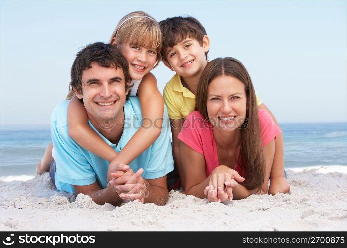 Family Relaxing On Beach Holiday