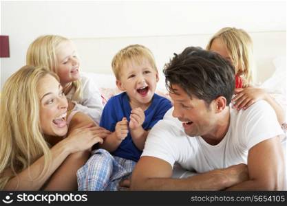 Family Relaxing Together In Bed