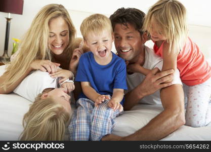 Family Relaxing Together In Bed