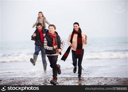Family Running Along Winter Beach
