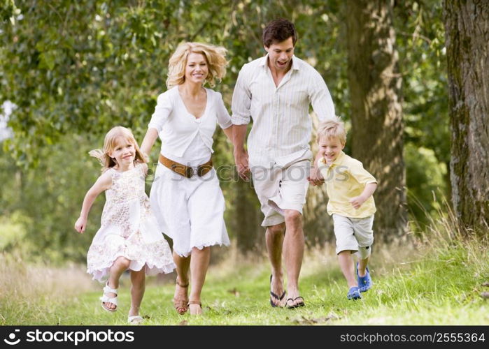 Family running on path holding hands smiling