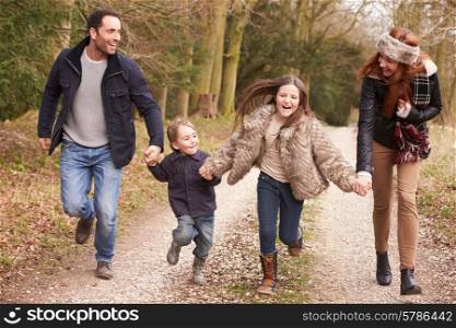Family Running On Winter Countryside Walk Together