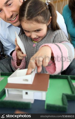 Family sat with model of new house