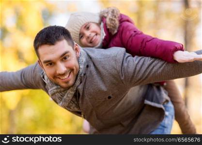 family, season and people concept - happy father and little daughter playing at autumn park. happy father and daughter playing at autumn park