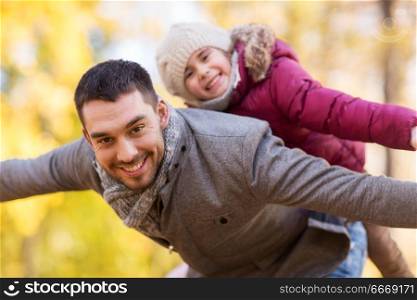 family, season and people concept - happy father and little daughter playing at autumn park. happy father and daughter playing at autumn park. happy father and daughter playing at autumn park