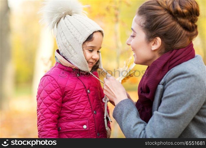 family, season and people concept - happy mother and little daughter at autumn park. happy mother and little daughter at autumn park. happy mother and little daughter at autumn park