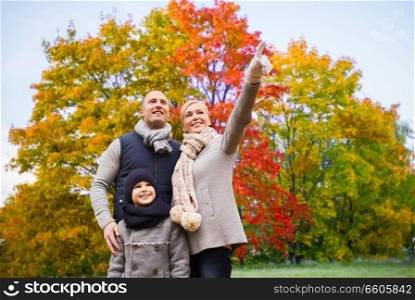 family, season and people concept - happy mother, father and son over autumn park background. happy family over autumn park background