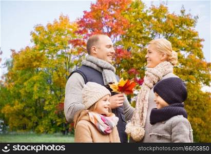 family, season and people concept - happy mother, father, daughter and son over autumn park background. happy family over autumn park background