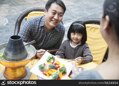 Family sharing and eating Chinese food outside