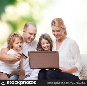family, shopping, technology and people - happy family with laptop computer and credit card over green background