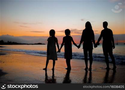 Family silhouette in the sunset on beach vacation. Family silhouette in the sunset at the beach