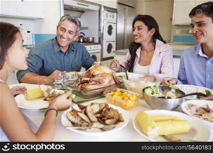 Family Sitting Around Table At Home Eating Meal